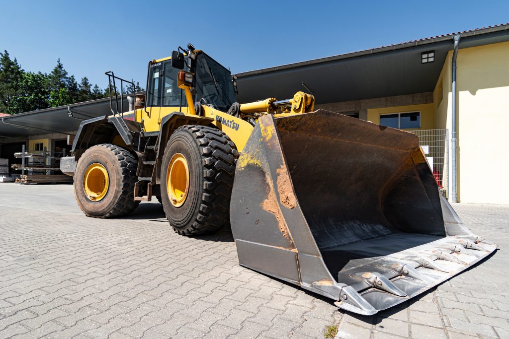 großer Radlader in der Seitenansicht vor der Firmenhalle